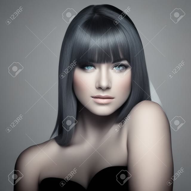 Ritratto di bella modello femminile su sfondo grigio