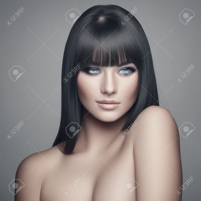 Ritratto di bella modello femminile su sfondo grigio