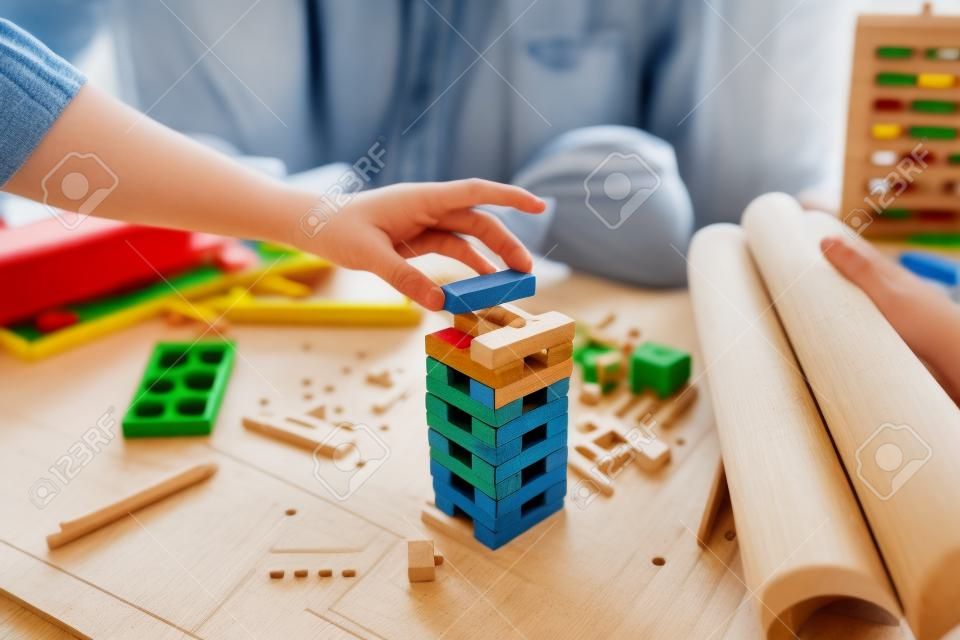 Engineering play. Blocks wood tower game (jenga) on blueprint factory, industry layout. Engineer and architect concept.