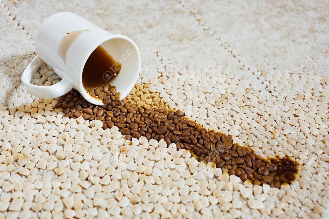 La taza de café cayó sobre la alfombra. La mancha está en el suelo.