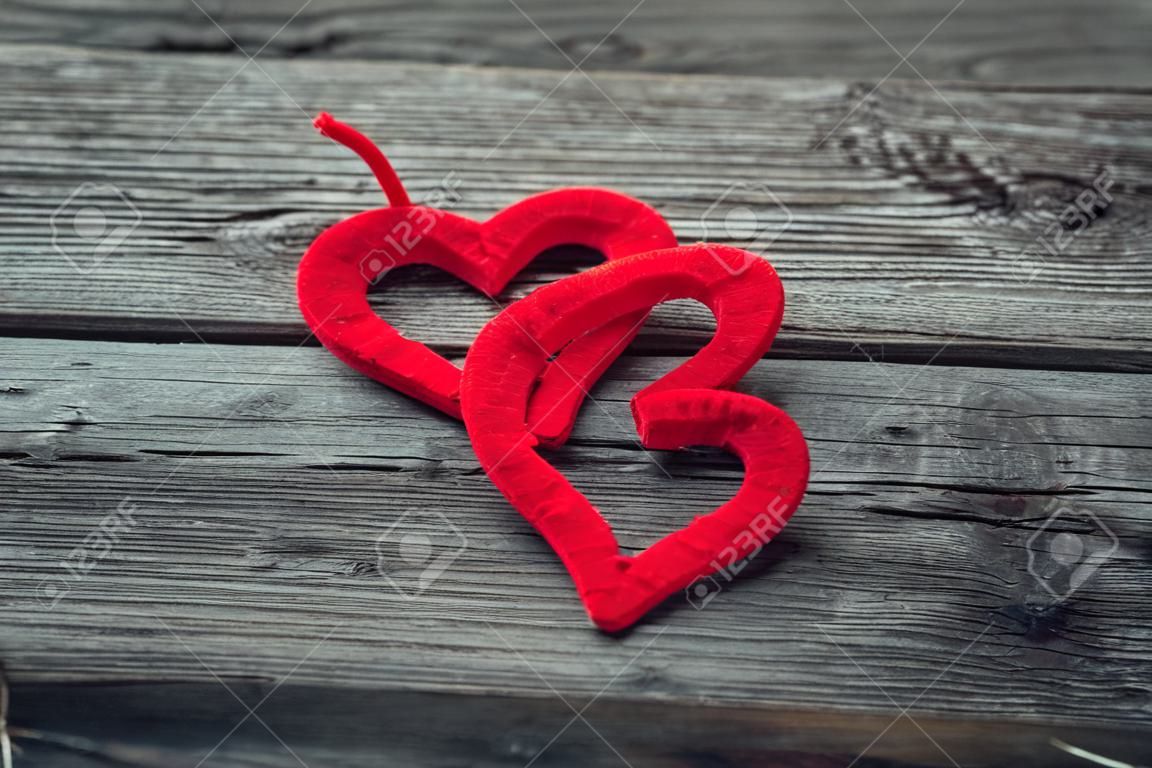 Twee rode harten op oude sjofele houten achtergrond. Vintage Valentijns achtergrond.