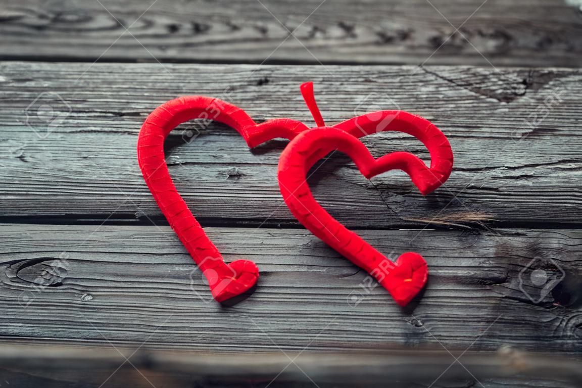 Dois corações vermelhos no fundo de madeira velho. Fundo de Valentim vintage.