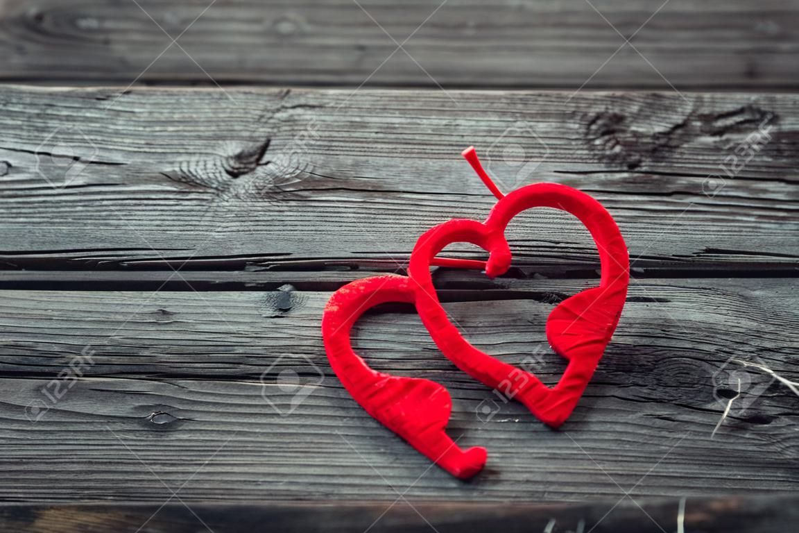 Two red hearts on old shabby wooden background. Vintage Valentine background.