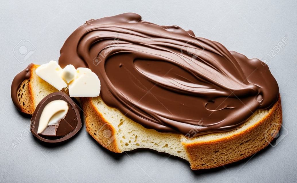 Snijden van brood met chocoladecrème met hazelnoot geïsoleerd op witte achtergrond