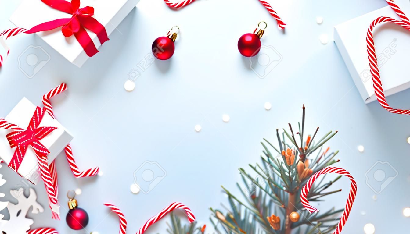 Disegno Noel. Confezione regalo bianca con nastro rosso, palline di Capodanno e albero d'inverno in composizione natalizia su sfondo bianco per biglietto di auguri. Sfondo di Natale con spazio per il testo