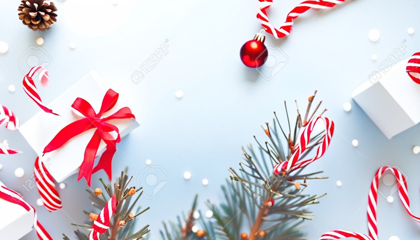 Conception de Noël. Coffret blanc avec ruban rouge, boules du Nouvel An et arbre d'hiver dans la composition de Noël sur fond blanc pour carte de voeux. Toile de fond de Noël avec un espace pour le texte