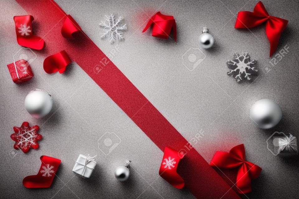 Venta de Navidad. Calcetín, regalos, árbol de invierno, cinta y arco en forma de marco sobre fondo blanco y rojo para tarjeta de felicitación. Composición festiva de invierno con espacio de copia.