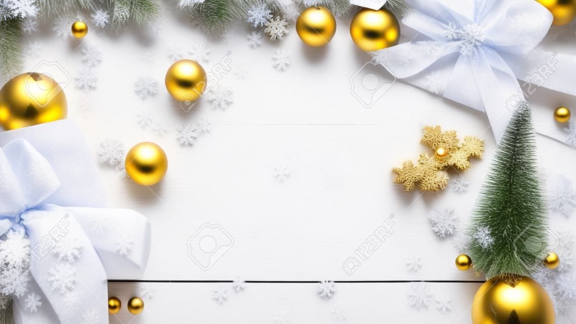 Kerstmis frame. Winter houten decoratie achtergrond. Kerstbord met oude rustieke muur, witte bevroren sneeuw, gouden ballen en geschenkdoos. Nieuwjaar met kopieerruimte