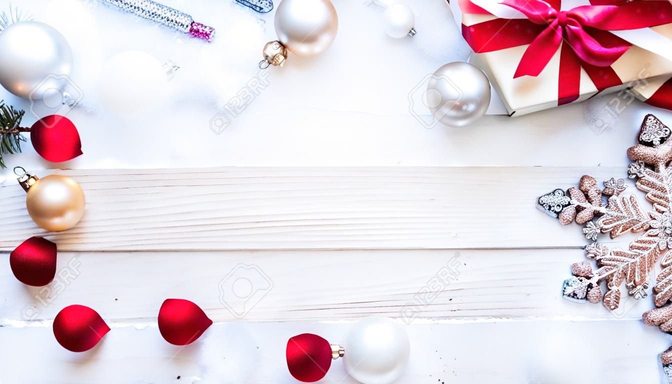 Cornice di Natale. Priorità bassa della decorazione di legno di inverno. Tavola di Natale con vecchio muro rustico, neve bianca ghiacciata, palline dorate e confezione regalo. Capodanno con copia spazio