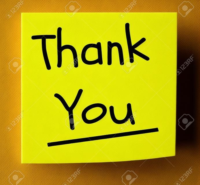 Un carré pad collant jaune note avec les mots de remerciement écrit en noir.