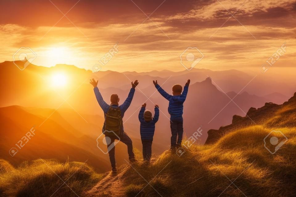 Buon padre e bambini che fanno un'escursione sulle montagne del tramonto