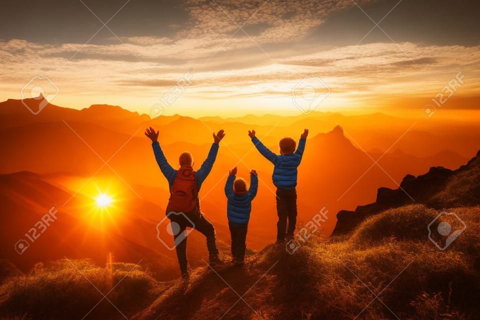 Buon padre e bambini che fanno un'escursione sulle montagne del tramonto