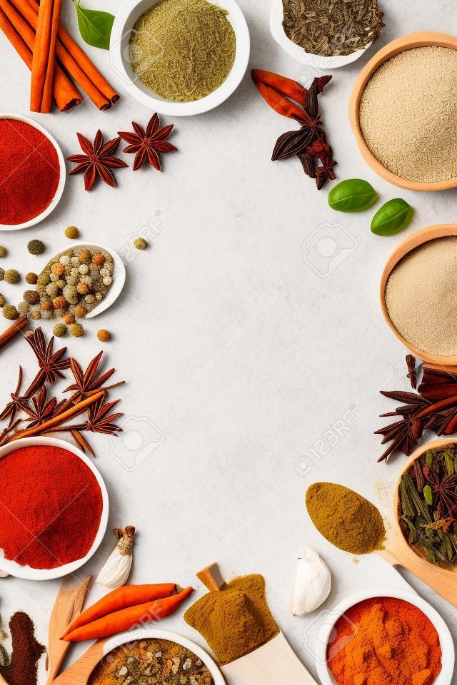Spices and herbs on white stone table.