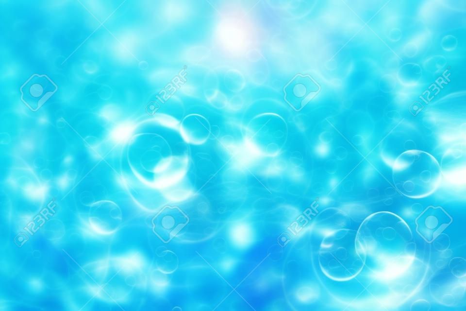 Reflections of the sun, a bunch of bubbles in the wavy water. Blue textured background. Closeup, selective focus, defocus