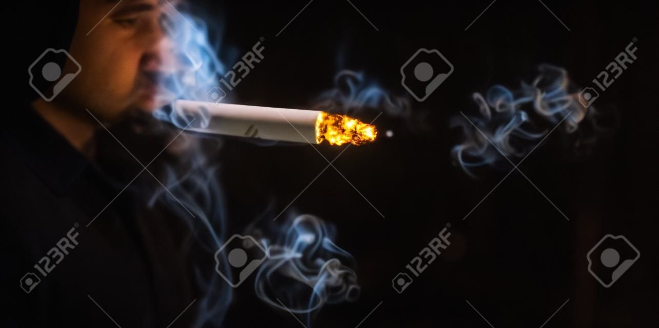 Курение сигареты на темном фоне