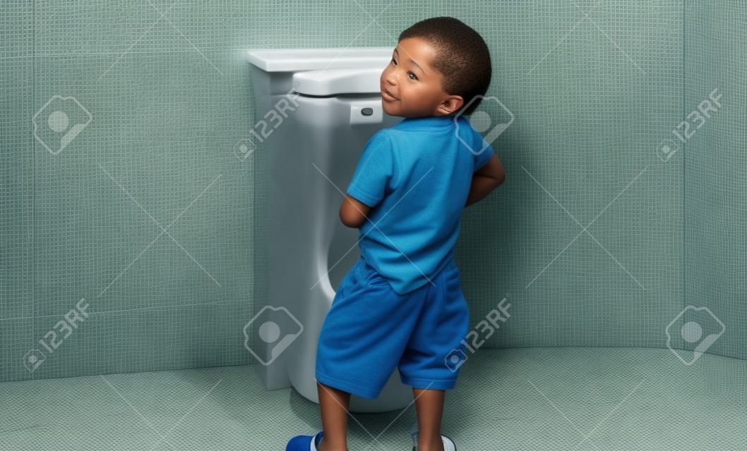 A boy is pissing himself in the bathroom.