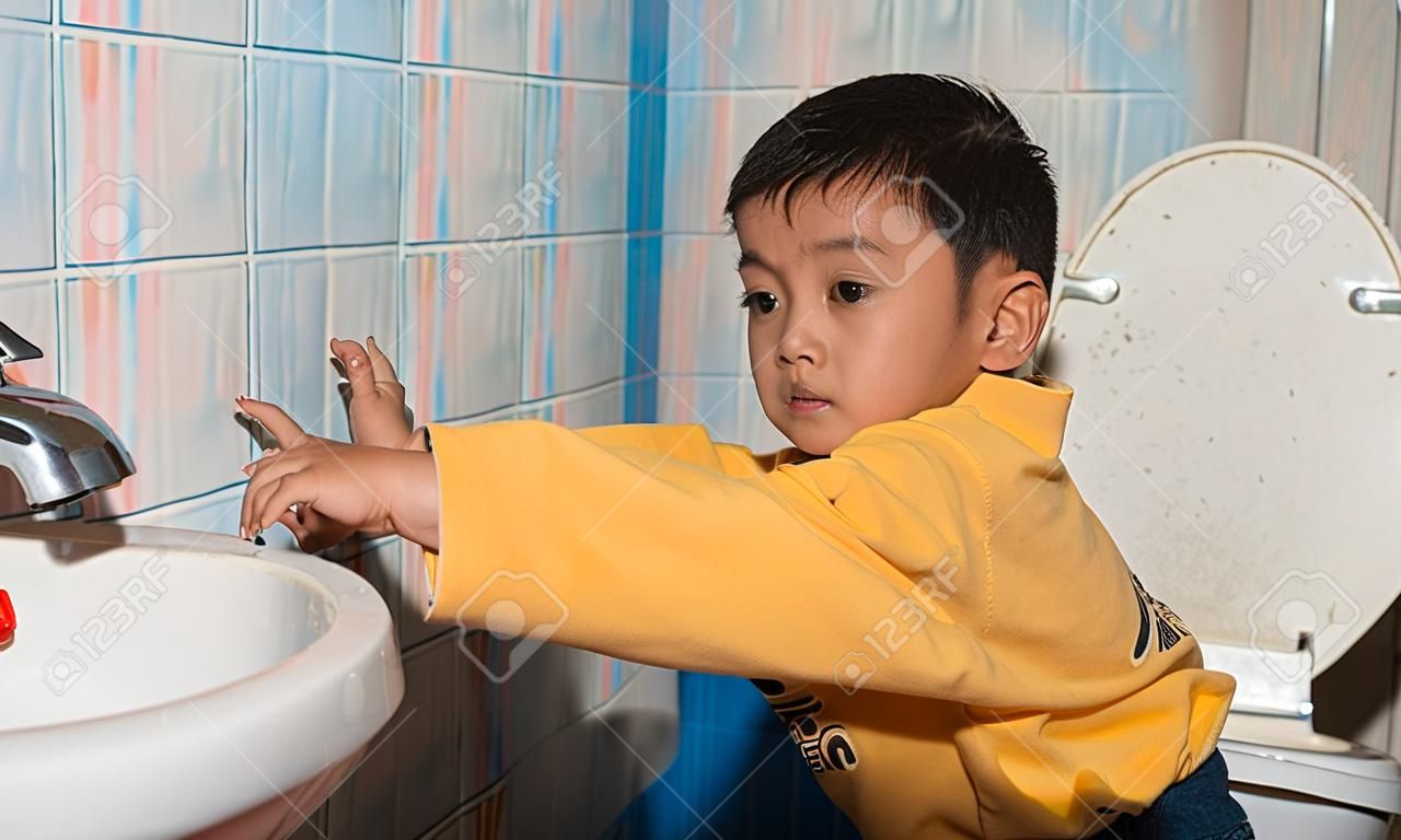 cute child little asian boy defecate in toilet