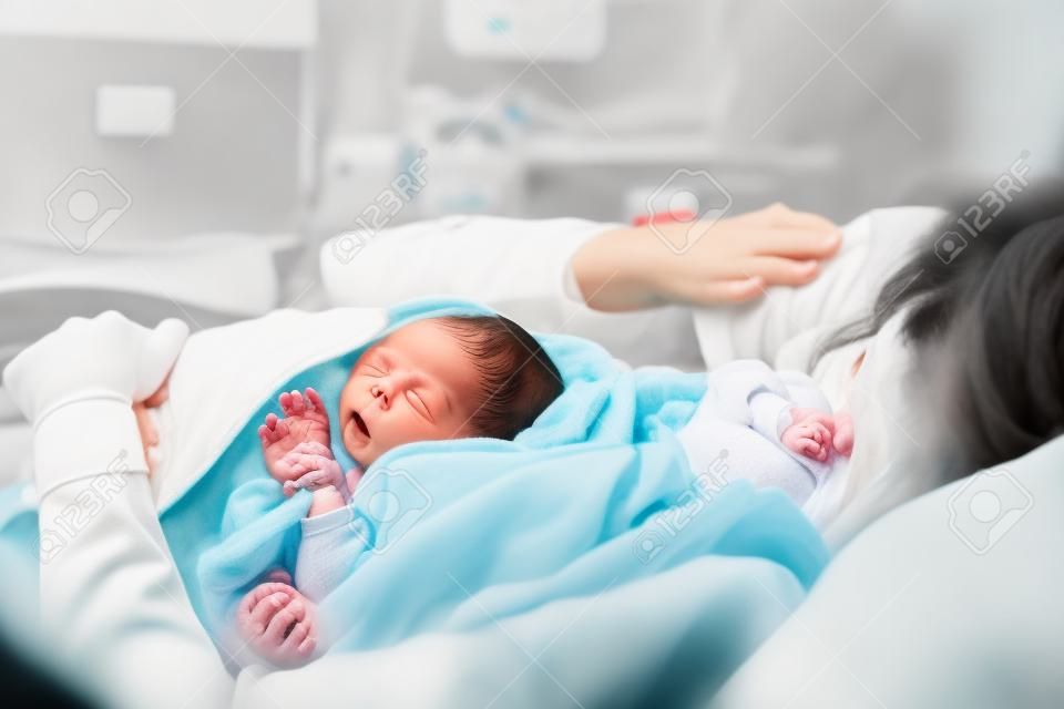 어머니와 신생아. 산부인과 병원에서 출산. 출산 후 갓 태어난 아기를 안고 있는 어린 엄마. 출산하는 여자. 분만 후 아기의 삶의 첫 순간.