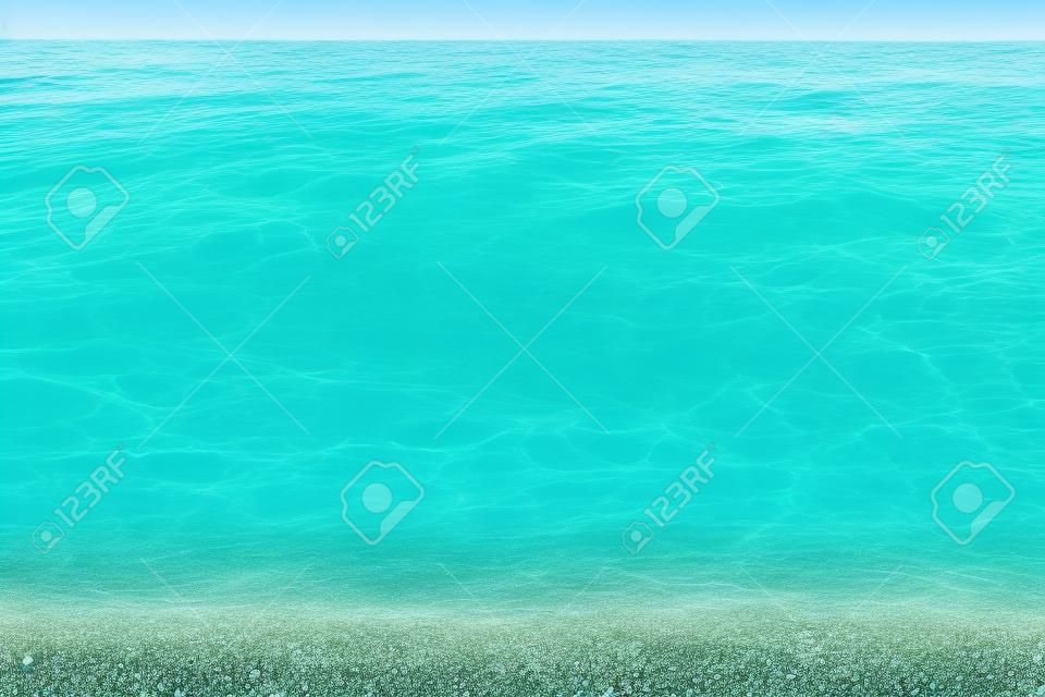 Summer turquoise sea. Beautiful clear water and gravel. Seamless background, natural texture. High quality photo