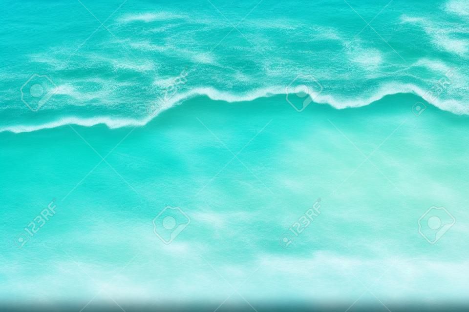 모래 해변에 푸른 바다의 부드러운 파도의 배경 이미지입니다. 바다 물결 가까 이서 텍스트 복사 공간