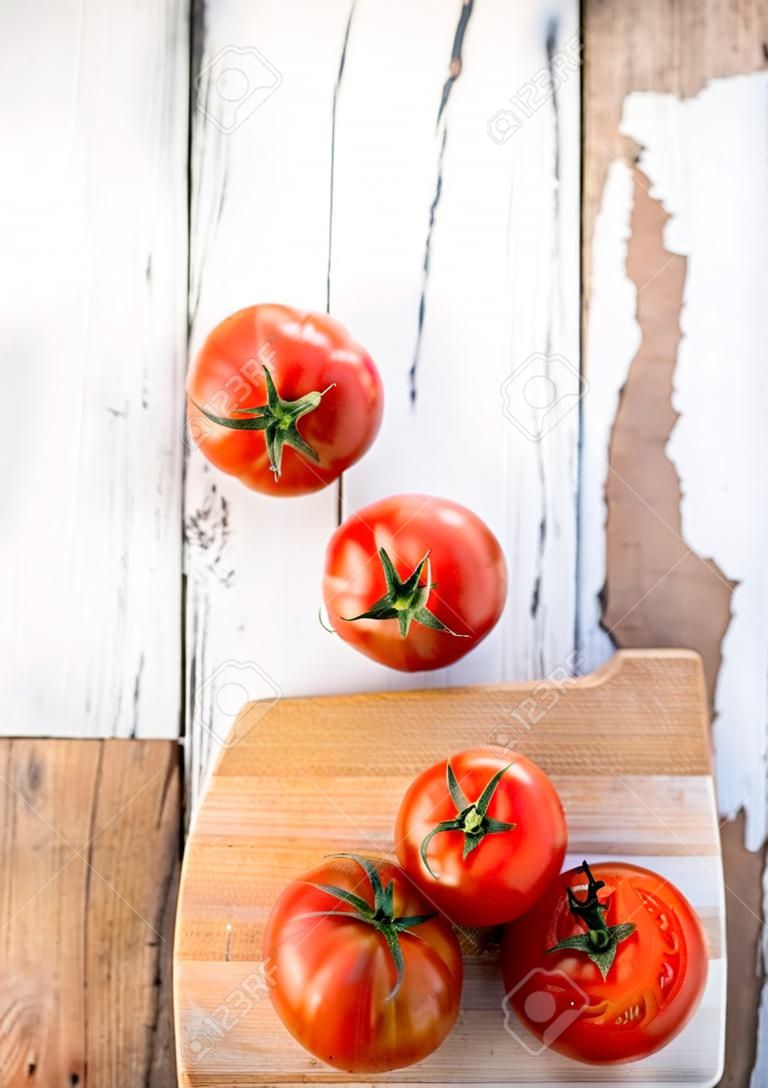 Ripe  tomatoes  on cutting board on  old wooden table, copyspace. Beefsteak tomatoes kind for cooking. Food organic concept
