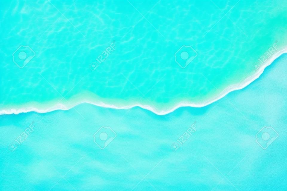 Fond d'été avec vague douce de l'océan bleu sur la plage de sable