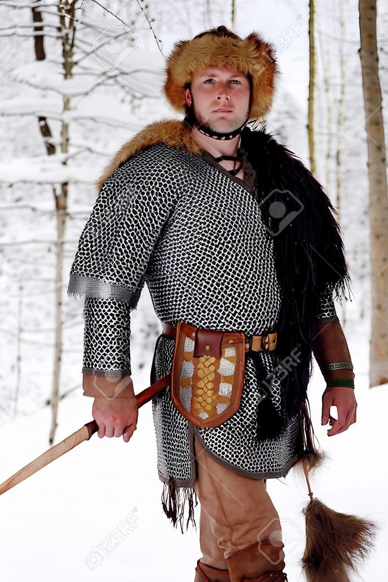 Portrait d'un homme guerrier viking. Guerrier viking avec lance en cuir de cotte de mailles marchant dans les bois d'hiver avant la bataille, vêtements traditionnels scandinaves pour bûcheron, concept viking.