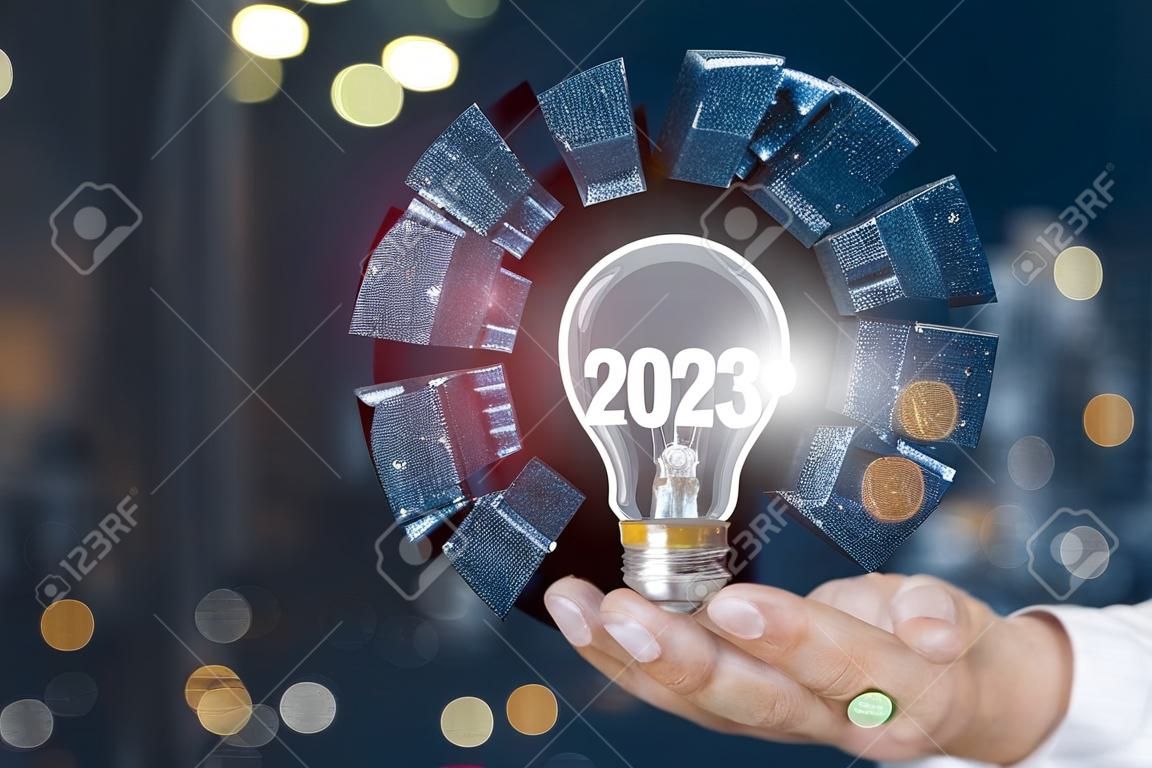 Koncepcja nowych pomysłów w 2023 roku dla biznesu. biznesmen pokazuje żarówkę z napisem 2023.
