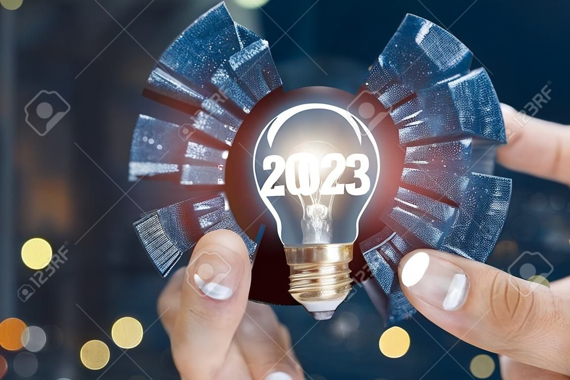Koncepcja nowych pomysłów w 2023 roku dla biznesu. biznesmen pokazuje żarówkę z napisem 2023.