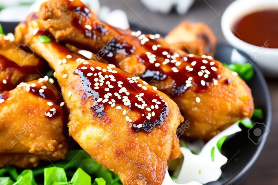 Fried chicken legs with teriyaki sauce and sesame seeds