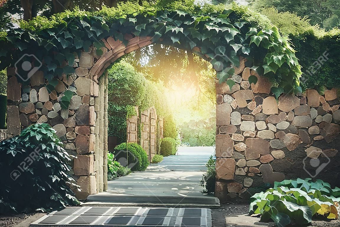 Muro de entrada de arco de piedra con hiedra en el jardín.
