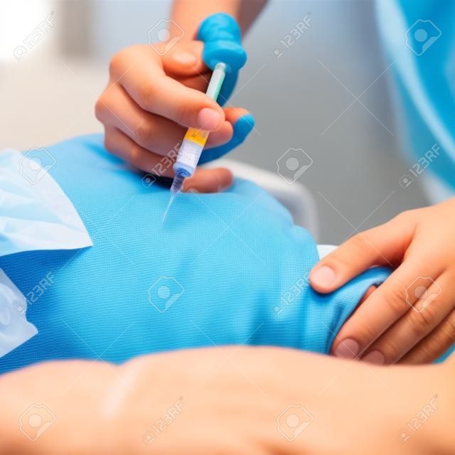 Doctor giving a child an intramuscular injection, shallow DOF