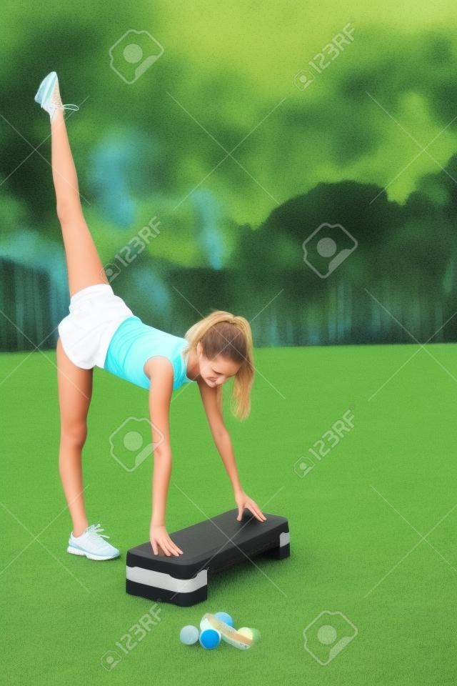 Un'adolescente carina e graziosa esegue vari esercizi all'aperto. Stile di vita