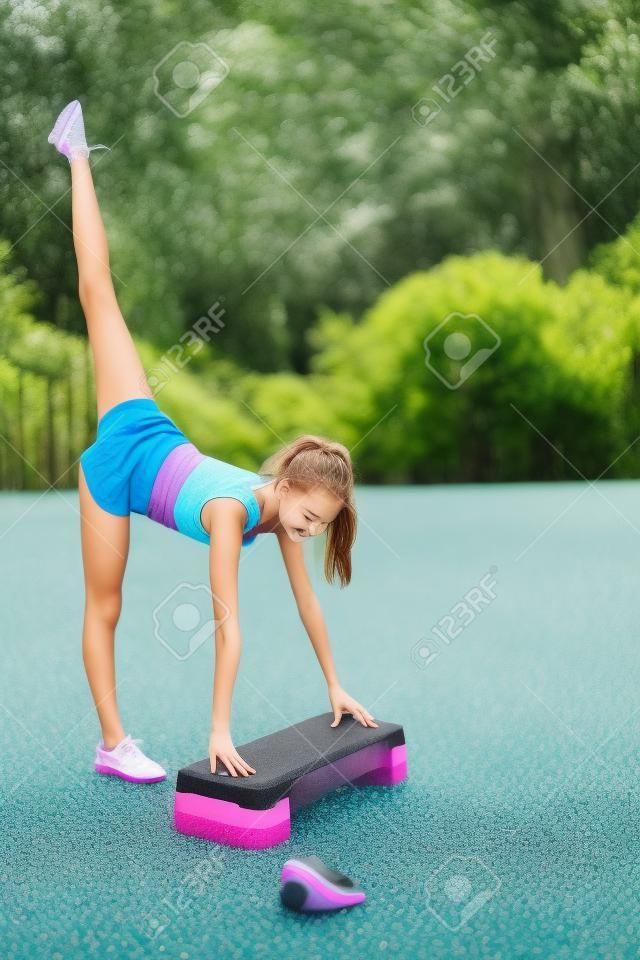 Una linda y guapa adolescente realiza varios ejercicios al aire libre. Estilo de vida