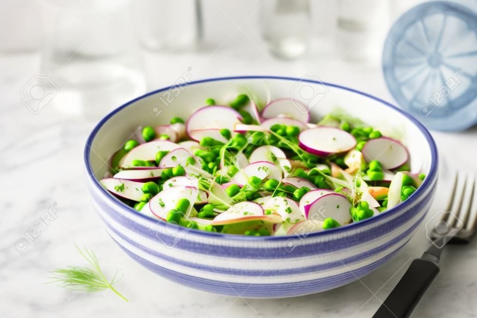 Fresh summer fennel salad with pea shoots and radishes in the bowl