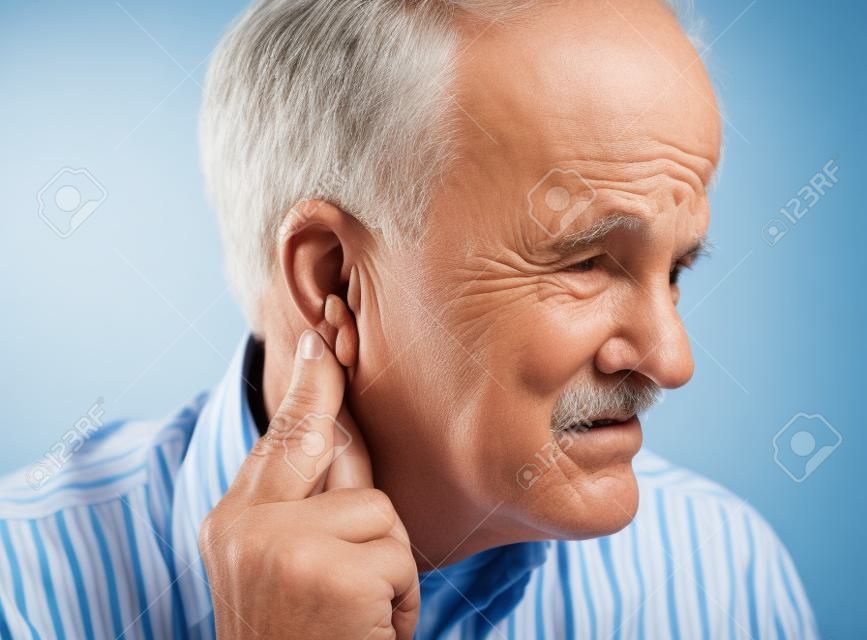 senior man suffers from pressure behind his ear