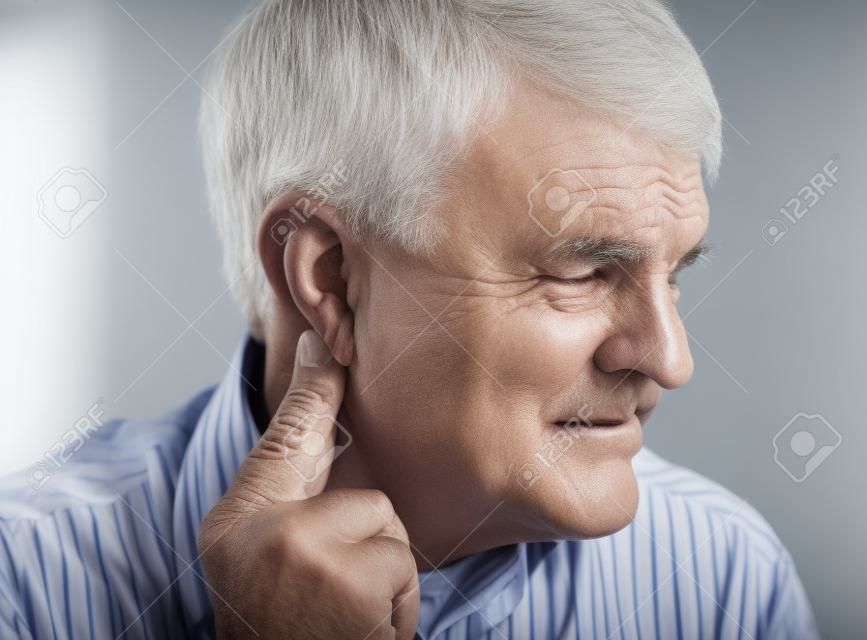 homem mais velho sofre de pressão atrás de seu ouvido