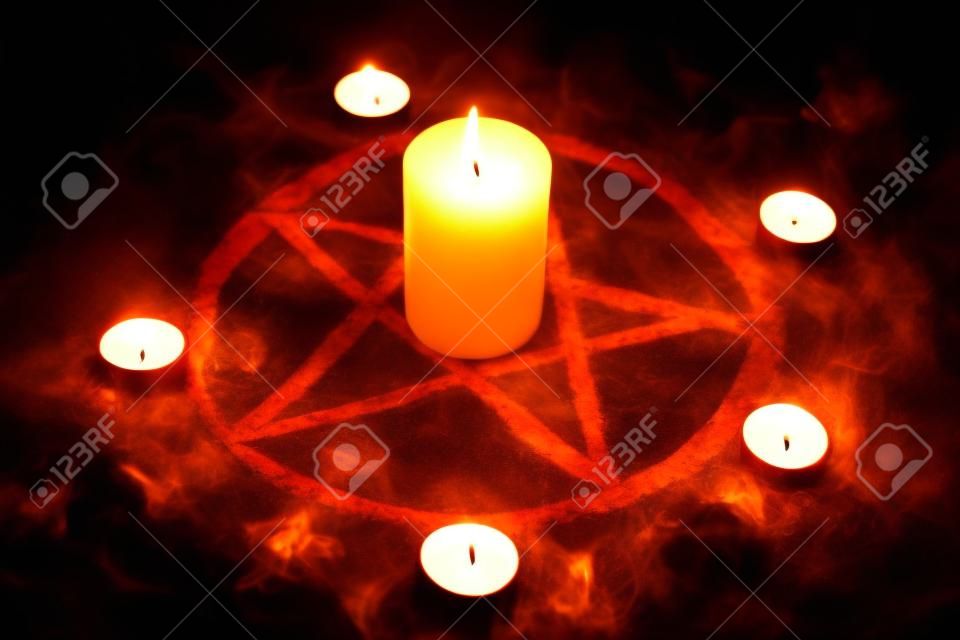 Pentagramme et bougies allumées. Le rituel magique du satanisme, invocation des esprits, séances spiritualistes.