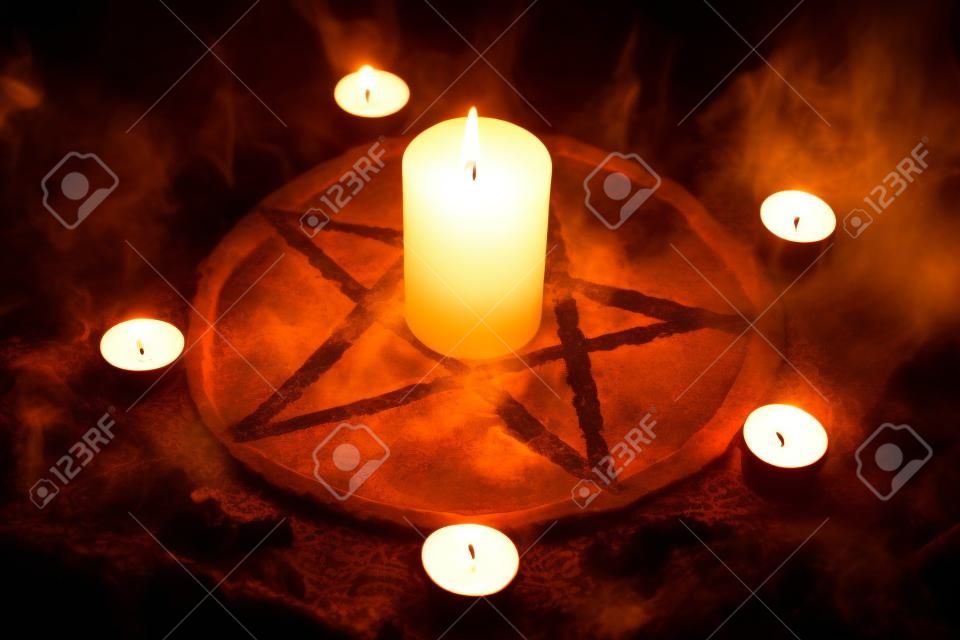 Pentagramme et bougies allumées. Le rituel magique du satanisme, invocation des esprits, séances spiritualistes.