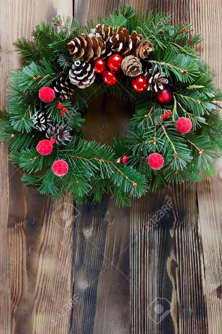 christmas decorated evergreen  wreath  on  aged wooden  background