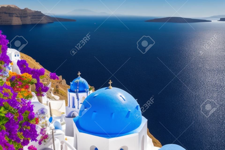 view of caldera with blue church domes, Oia with flowers, Santorinir