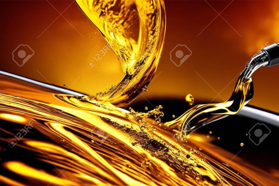 Spruzzi di olio motore per auto, versando carburante liquido in color oro