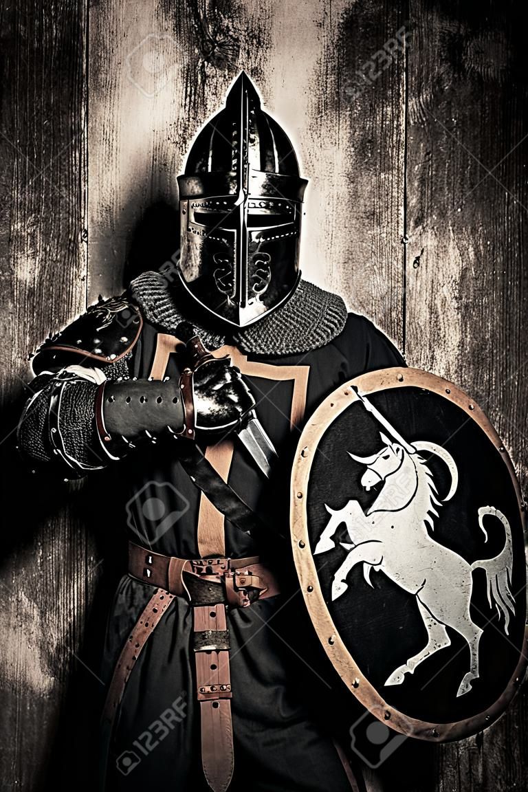 Middeleeuwse ridder met zwaard voor zijn gezicht