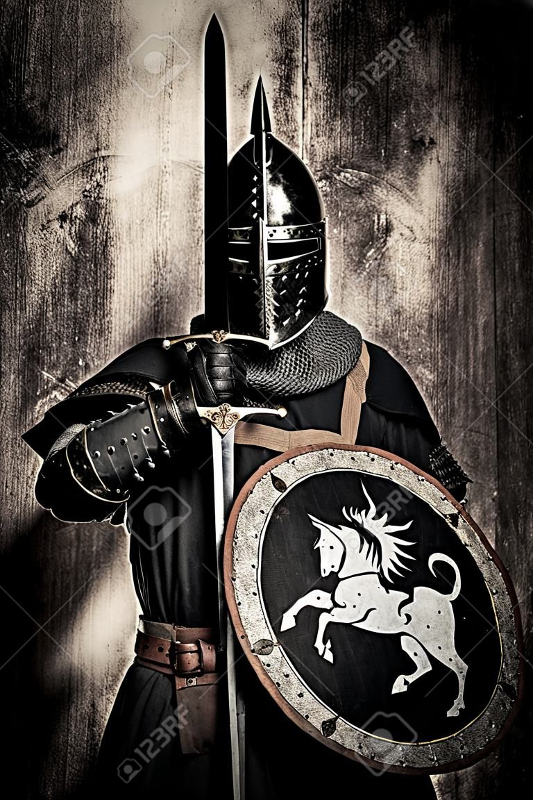 Middeleeuwse ridder met zwaard voor zijn gezicht