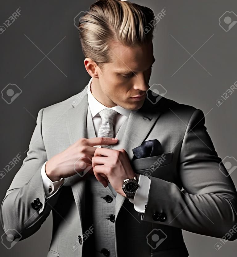 Przekonany, ostre ubrany mężczyzna w szarym garniturze