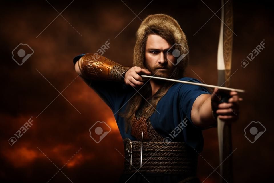 vikingo serio con el arco y la flecha en un tradicional ropa de guerrero, que presenta en un fondo oscuro.