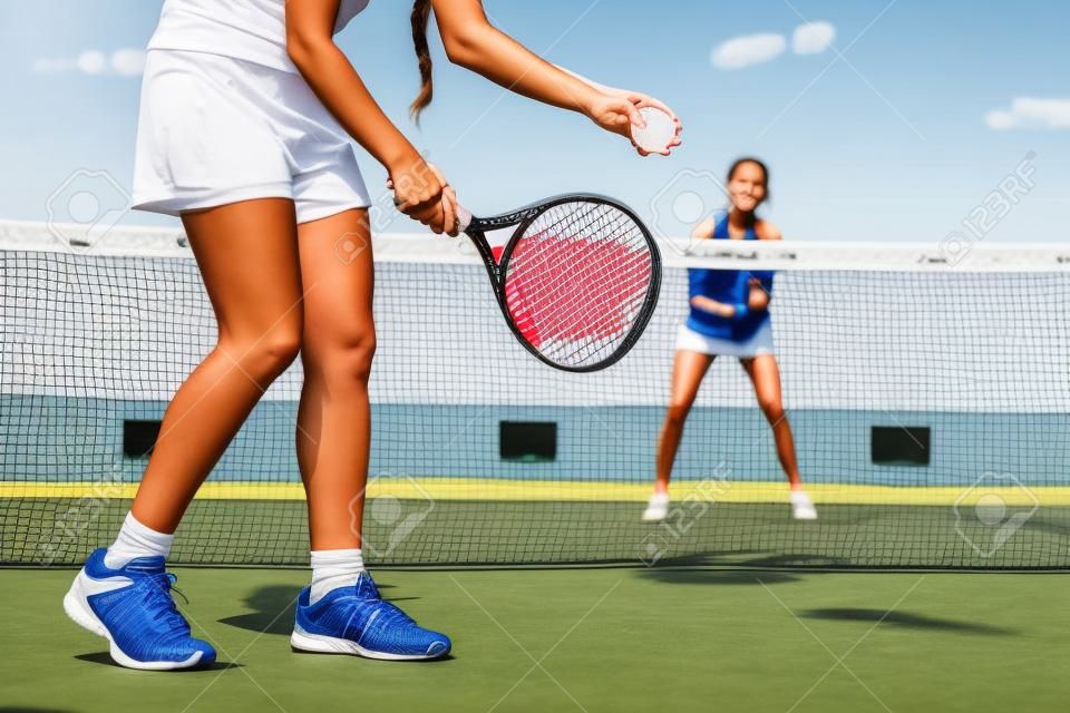 Portrait of two young women playing paddle tennis.