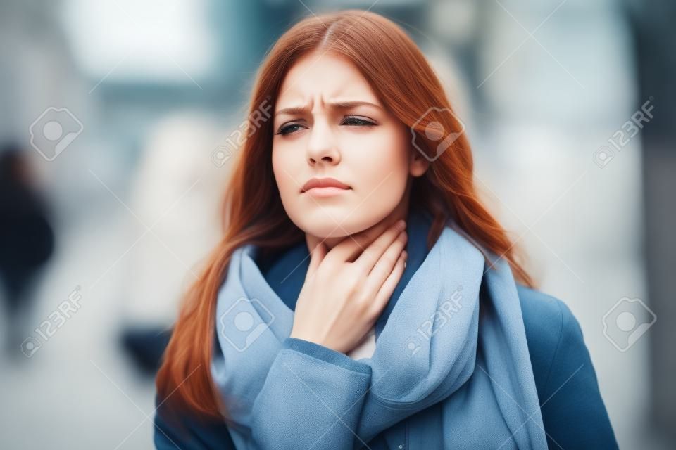 Tiro de doença jovem mulher com dor de garganta terrível caminhando para a rua.