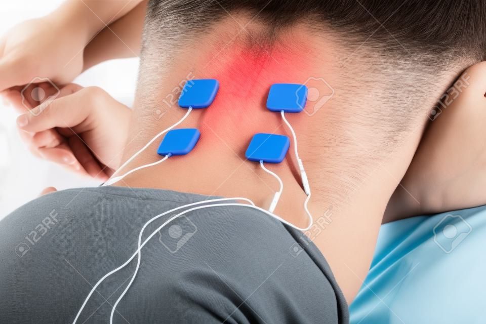 Patient, der auf dem Rücken elektrische Stimulationstherapie anwendet. Elektrische Zehner.
