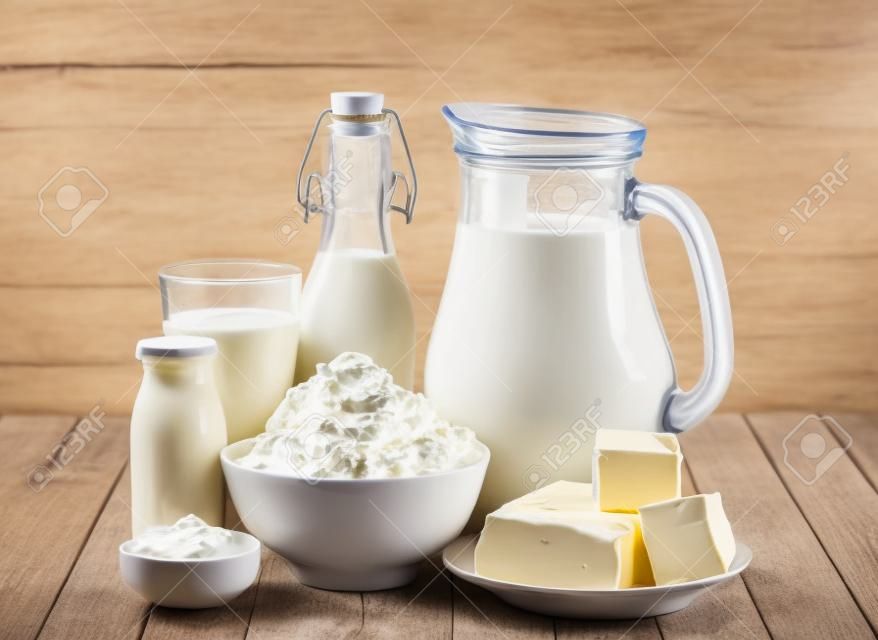 Produtos lácteos, leite, queijo cottage, iogurte, creme azedo e manteiga na mesa de madeira